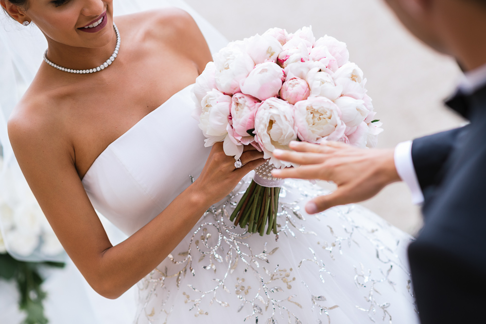 Bride wearing Dior dress exchanging rings with groom at Chateau de Chantilly