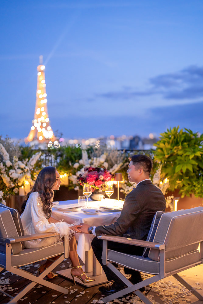 Stylish couple enjoying private dinner after Paris engagement on a rooftop with a view